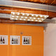 Fabbian Sospesa Hängeleuchte 24-flammig schwebt elegant über einem orangenen Wanddesign.