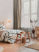 Fado Wandleuchte Ø 20,5cm E27 Rattan in einem stilvollen Schlafzimmer mit Rattanmöbeln und modernen Akzenten.