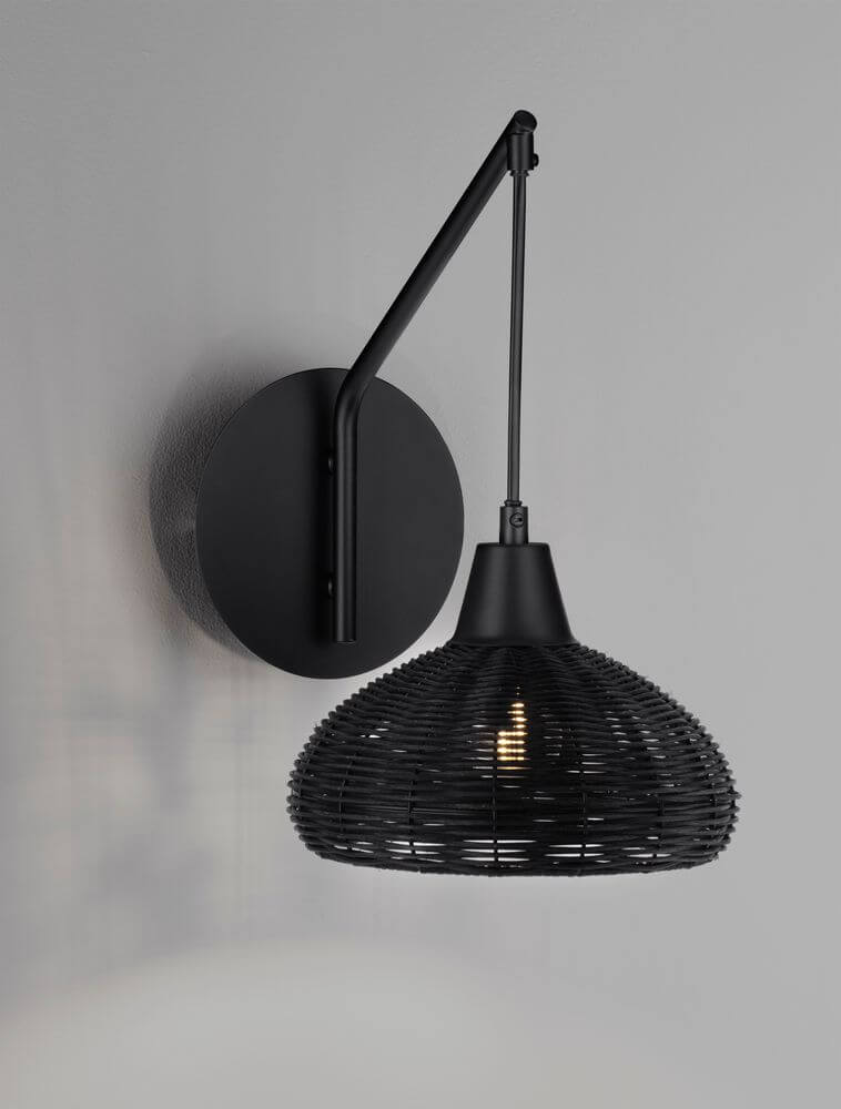 Fado Wandleuchte Ø 20,5cm E27 Rattan an der Wand mit schwarzem Design und Rattan-Applikationen.