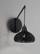 Fado Wandleuchte Ø 20,5cm E27 Rattan an der Wand mit schwarzem Design und Rattan-Applikationen.