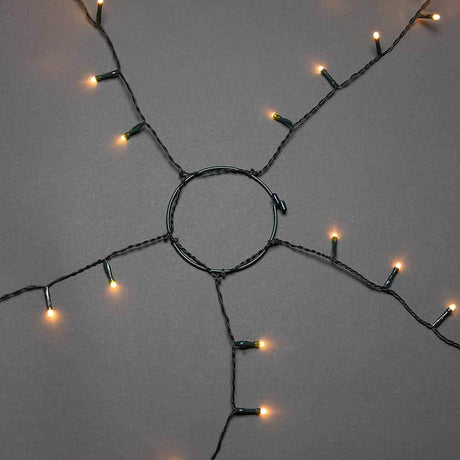 Feierlicher LED Baummantel mit Befestigungsring IP20 auf grauem Hintergrund mit leuchtenden Lichtern.