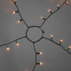 Feierlicher LED Baummantel mit Befestigungsring IP20 auf grauem Hintergrund mit leuchtenden Lichtern.