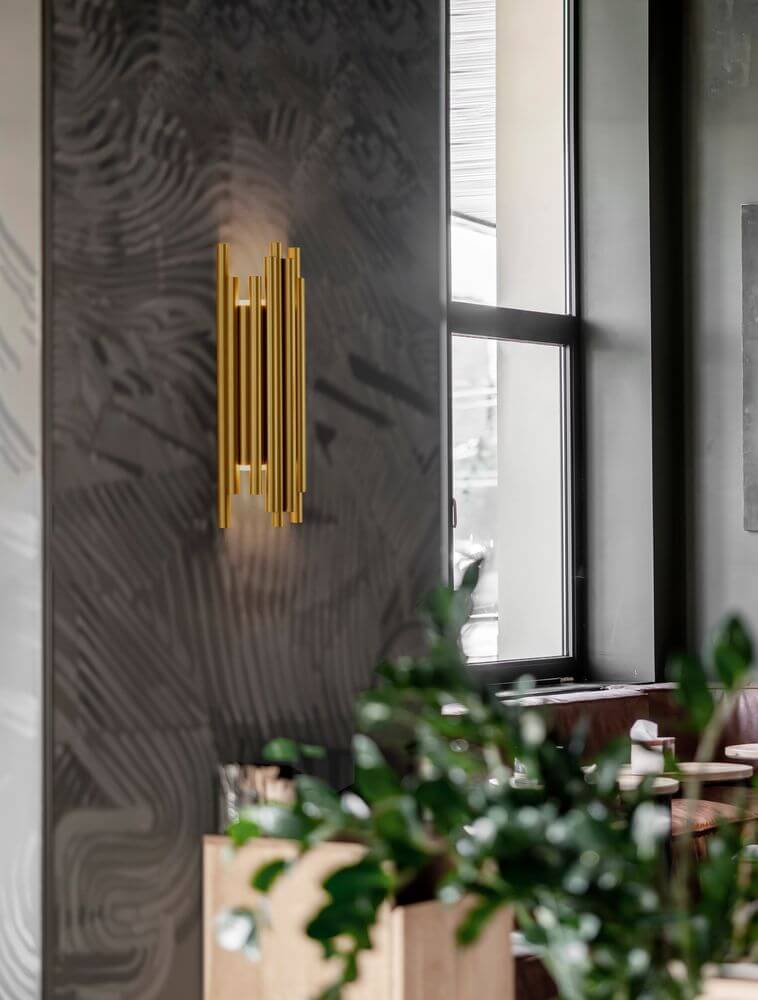 Felix LED Wandleuchte 3000K Gold an Wand in modernem Interieur mit Goldfinish und zylindrischen Aluminium-Elementen