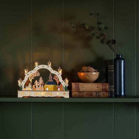 Festive wooden silhouette with church and snowman, battery-operated, brown, on a shelf.