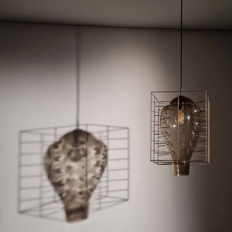 Lampe suspendue Attimo en verre de Murano dans une cage avec ombre portée sur le mur