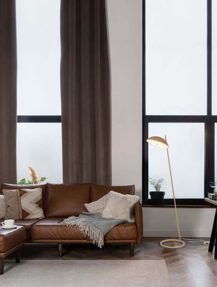 Flute LED Stehlampe H 153cm 3000K in modernem Wohnzimmer mit braunem Sofa und großen Fenstern.