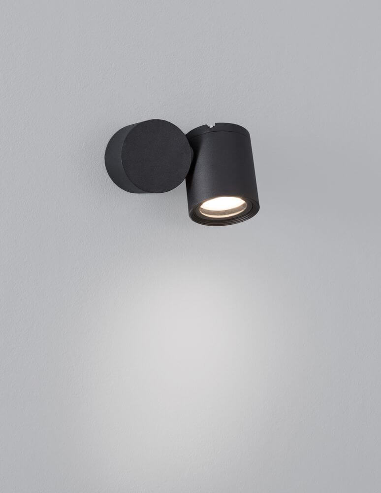 Focus Außenwandleuchte Rund GU10 Schwarz IP54 an einer grauen Wand montiert, minimalistisches Design.