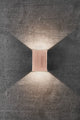 Elegante Fold 10 LED Außen-Wandleuchte aus Kupfer mit angenehmem Lichtschein auf Betonwand.