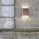 Falt 10 LED Außen-Wandleuchte in Kupfer montiert an einer Betonwand mit direkter Ausleuchtung.
