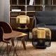 Forestier Bamboo Square Tischlampe in einem modernen Wohnambiente mit Holzstuhl und Couch.