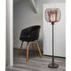Forestier Design-Stehlampe Bodyless neben einem modernen schwarzen Stuhl in einem eleganten Raum.