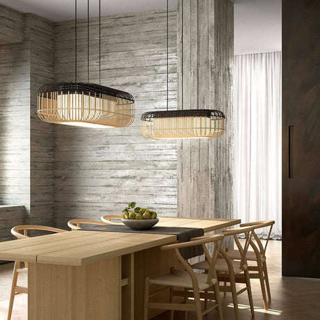 Forestier Esstisch-Hängeleuchte Bamboo Oval im modernen Zen-Stil über einem Holztisch mit Stühlen.