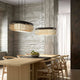 Forestier Esstisch-Hängeleuchte Bamboo Oval im modernen Zen-Stil über einem Holztisch mit Stühlen.