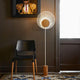 Forestier Stehlampe Oyster 145cm in einem modernen Raum mit schwarzem Stuhl und Kunstwerk an der Wand.