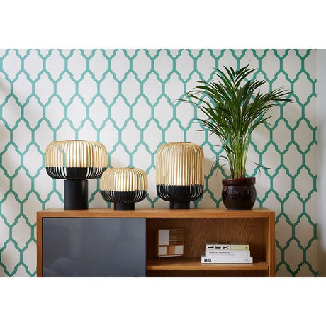 Forestier Tischlampe Bamboo Light in unterschiedlichen Größen auf einem Sideboard vor gehakter Tapete.