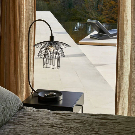 Forestier table lamp Papillon 62cm on a bedside table overlooking a terrace and water, modern design style.