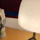 Lumiere 30th Grande Tavolo Tischleuchte Weiß auf einem Tisch, elegant mit Blumen im Hintergrund.
