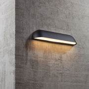 Front 36 LED buitenwandlamp IP44 zwart gemonteerd aan een betonnen muur met warm wit licht.