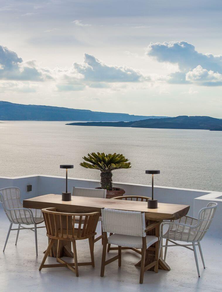 Fumo LED Außentischleuchte 3000K IP54 auf einem stilvollen Balkon mit Meerblick.