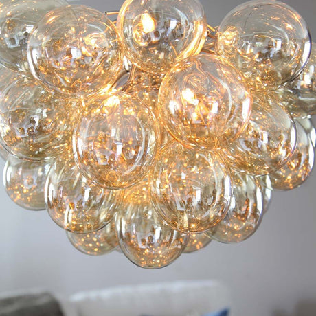 Lampada a sospensione in vetro di grandi dimensioni Gross Ø 50 cm ambra con sfere di vetro scintillanti che creano una luce calda.