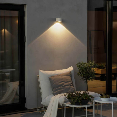 Gala LED Außen Wandleuchte Downlight an einer Hauswand mit gemütlicher Sitzgelegenheit im Freien.