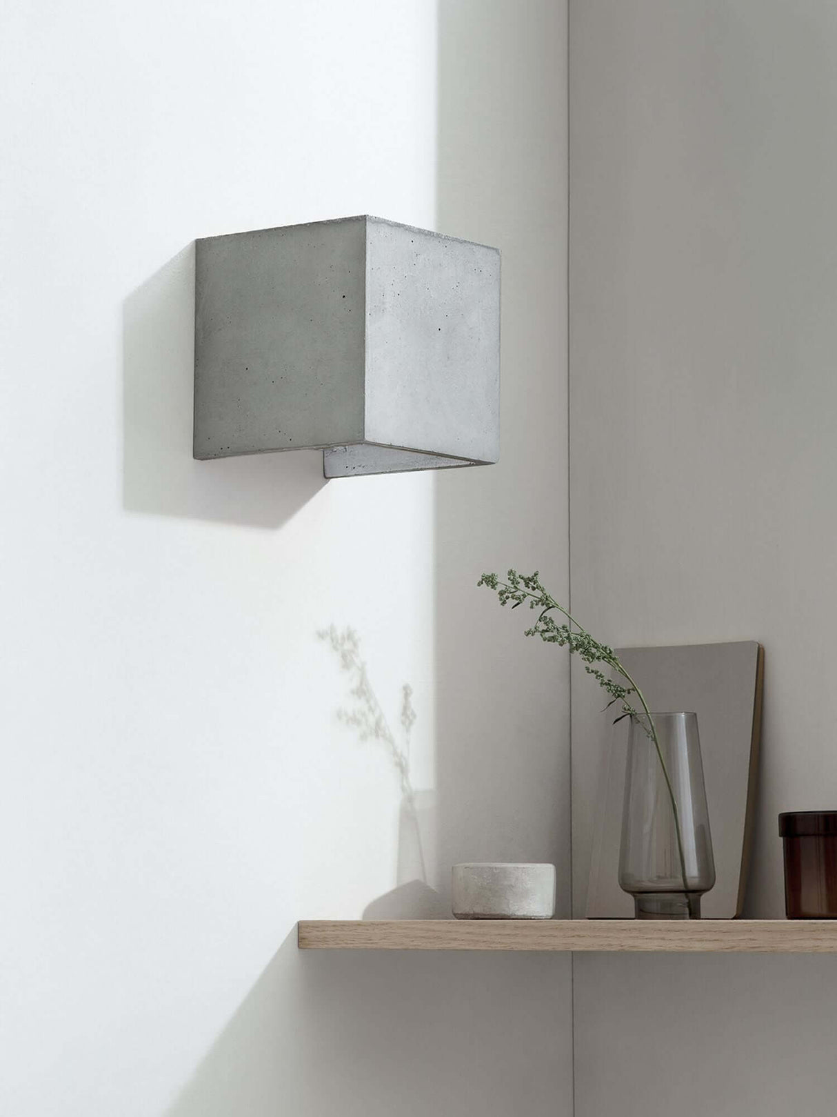 Gantlights B3 Wandlampe quadratisch Beton an heller Wand, sichtbare goldene Innenbeschichtung, warmes Licht nach oben und unten