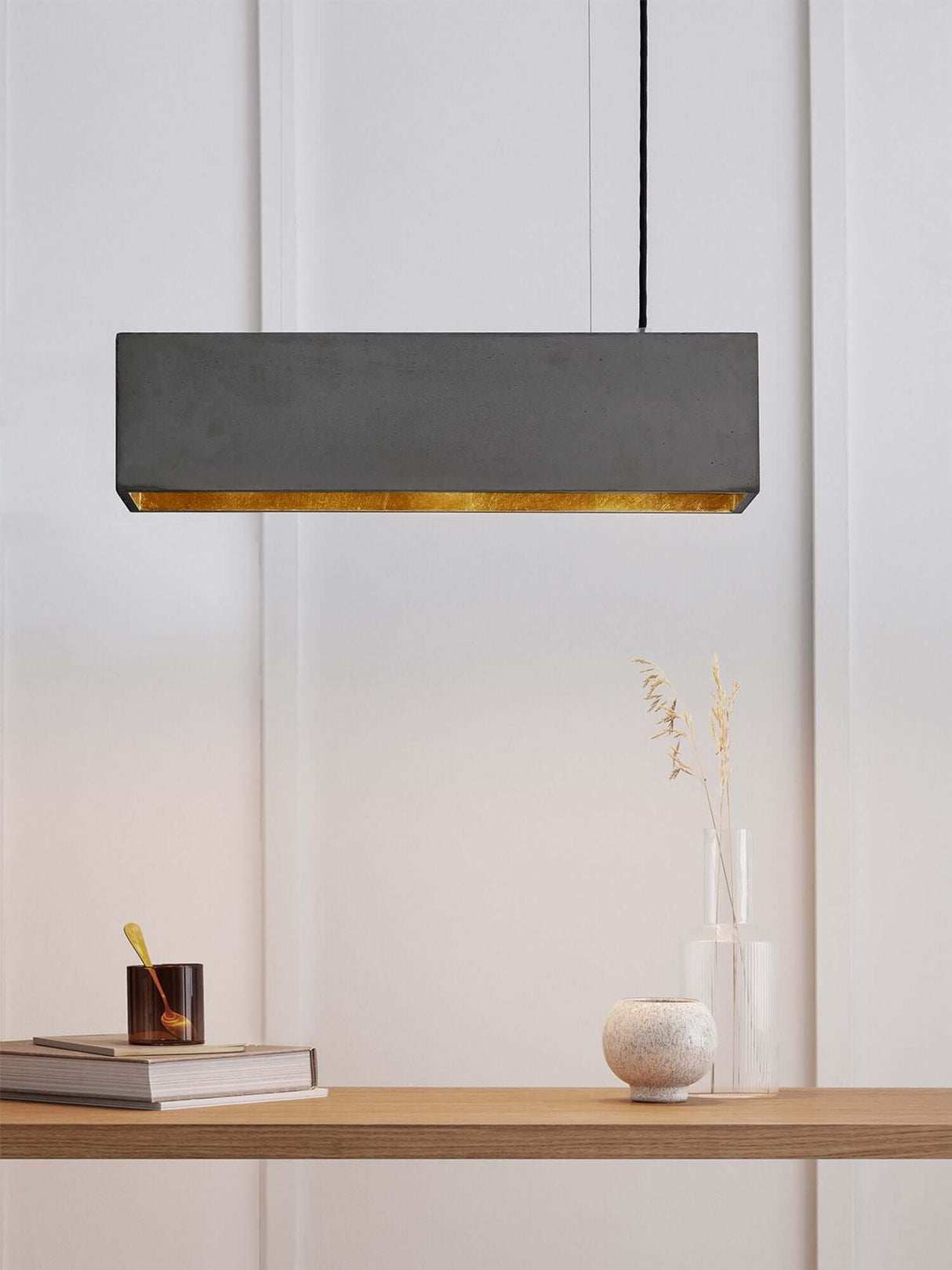 Gantlights B4 LED-Pendelleuchte Beton 56cm dimmbar an modernem Tisch mit Dekoration.