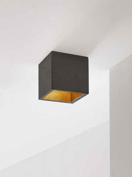 Alt Tag: Gantlights B7 Deckenspot quadratisch dimmbar aus grauem Beton mit vergoldetem Innenraum, minimalistischer kubischer Deckenstrahler