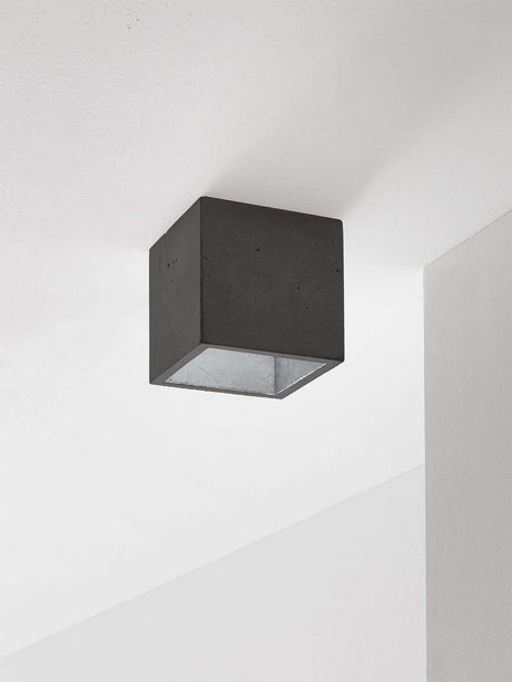Gantlights B7 Deckenspot quadratisch dimmbar aus grauem Beton, innen vergoldet/versilbert/verkupfert, minimalistischer Kubus an weißer Decke