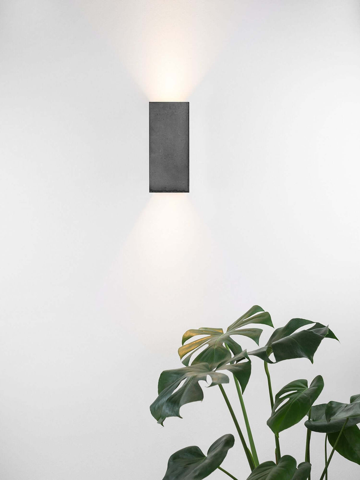 Gantlights B8 Beton Wandlampe rechteckig Up & Down an weißer Wand mit Gold-Innenbeschichtung und Up-Down-Licht, minimalistisches Design