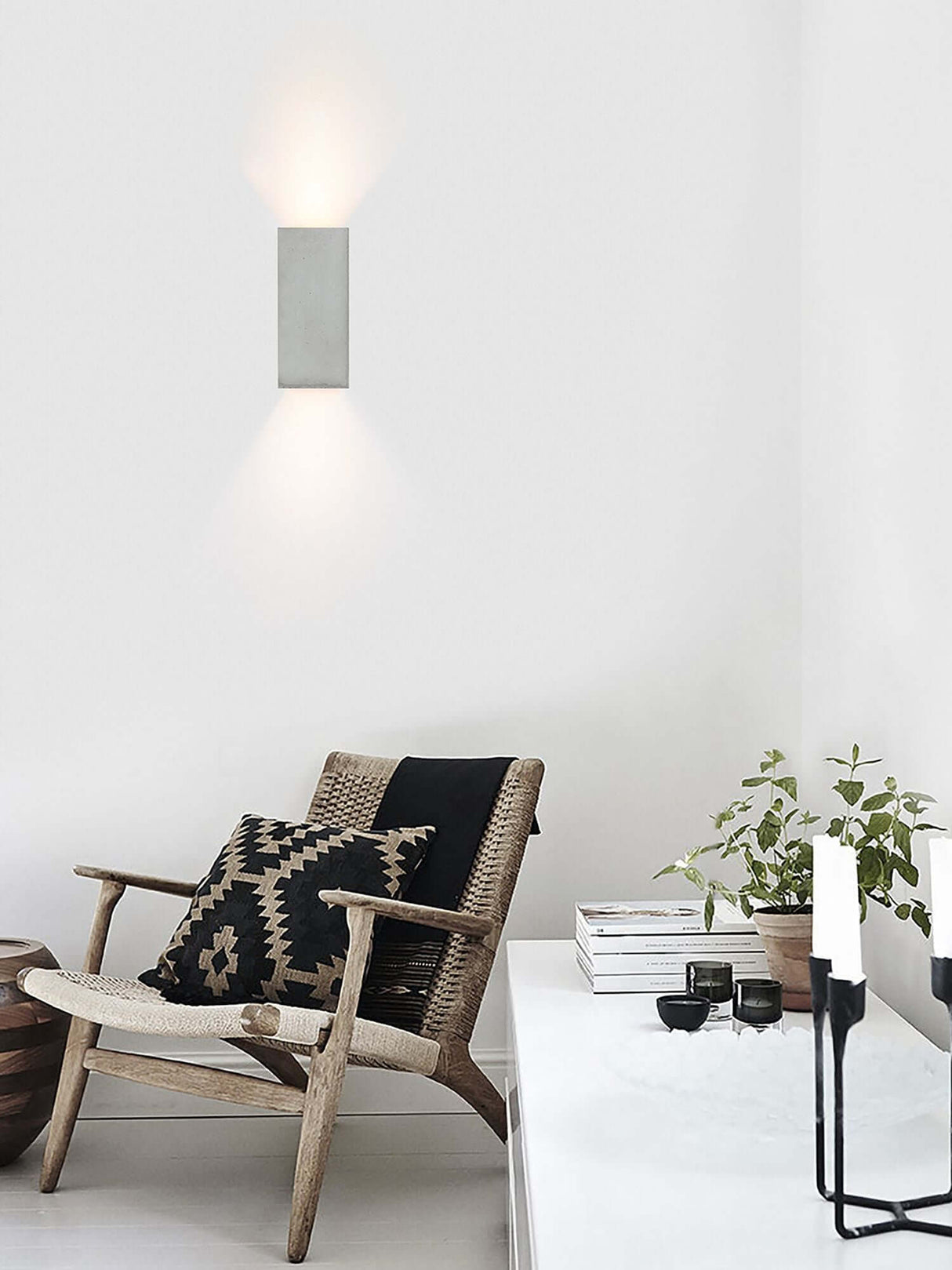 Gantlights B8 Beton Wandlampe rechteckig Up & Down an weißer Wand über gemütlichem Lesesessel, Betonoberfläche mit goldener Innenbeschichtung