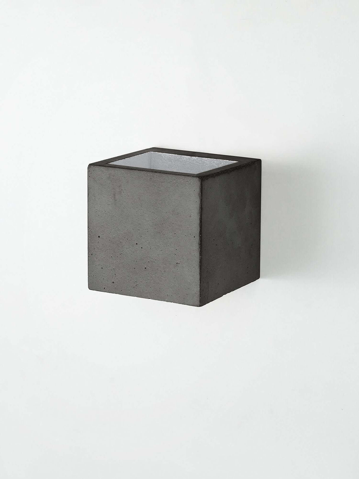 Gantlights B9 Wandleuchte Up & Down in quadratischem Design aus Beton an der Wand montiert.