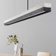 Gantlights C1 LED-Pendelleuchte 122cm Beton Holz über einem Esstisch mit minimalistischer Einrichtung.