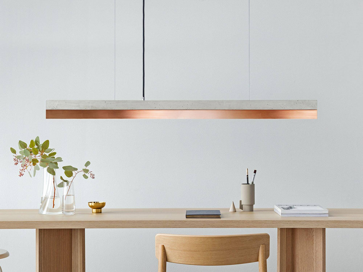 Gantlights C1 LED-Pendelleuchte 122cm Beton Holz über einem eleganten Holztisch.