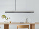 Gantlights C1 LED-Pendelleuchte 122cm Beton Holz über einem minimalistischen Esstisch in modernem Ambiente.