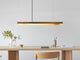 Gantlights C2 o/n LED-Pendellampe 92cm dimmbar über einem modernen Tisch in einem stilvollen Raum.