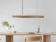Gantlights C2 o/n LED-Pendellampe 92cm dimmbar über einem modernen Tisch mit Holzdekor.