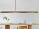Gantlights C3 o/n LED-Pendelleuchte 182cm dimmbar aus Eichenholz über einem modernen Tisch.