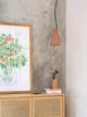 Gantlights S1 Beton Pendelleuchte geriffelt über einem Sideboard mit Pflanzenbild und Pinselhalter.