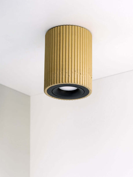 Gantlights S2 schwenkbarer Deckenspot Plissiert auf weißer Decke mit gerippter Oberfläche aus Beton.