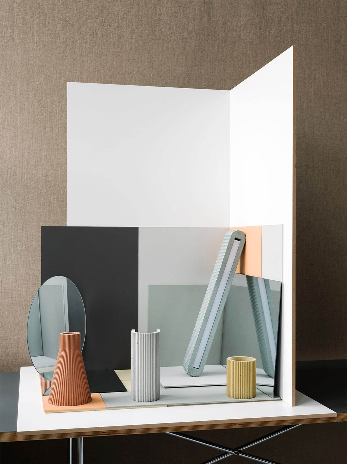 Dekorative Anordnung von Vasen und Spiegeln auf einem Tisch, moderne Wohnraumgestaltung mit geometrischen Formen.