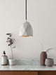 Gantlights T1 Pendelleuchte Beton in minimalistischer Einrichtung auf einem Tisch mit Pflanzen und Dekor.