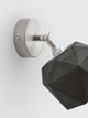 Gantlights T2 Wandspot Beton trianguliert auf einer Wand mit metallic Halterung und dreidimensionalem Betonlampe.