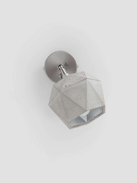 Gantlights T2 Wandspot Beton trianguliert in hellgrauem Beton mit edlen Metallakzenten.
