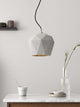Gantlights T3 Hängelampe aus Beton über einem Tisch, handgefertigte Designleuchte mit Beton und Gold.