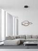 Ginevra LED Pendelleuchte Verknotet Ø 58cm 3000K Schwarz in modernem Wohnraum über hellem Sofa.