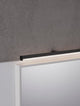 Glim LED Wandleuchte 3000K IP44 an einem Spiegel montiert, spritzwassergeschützt und modern gestaltet.