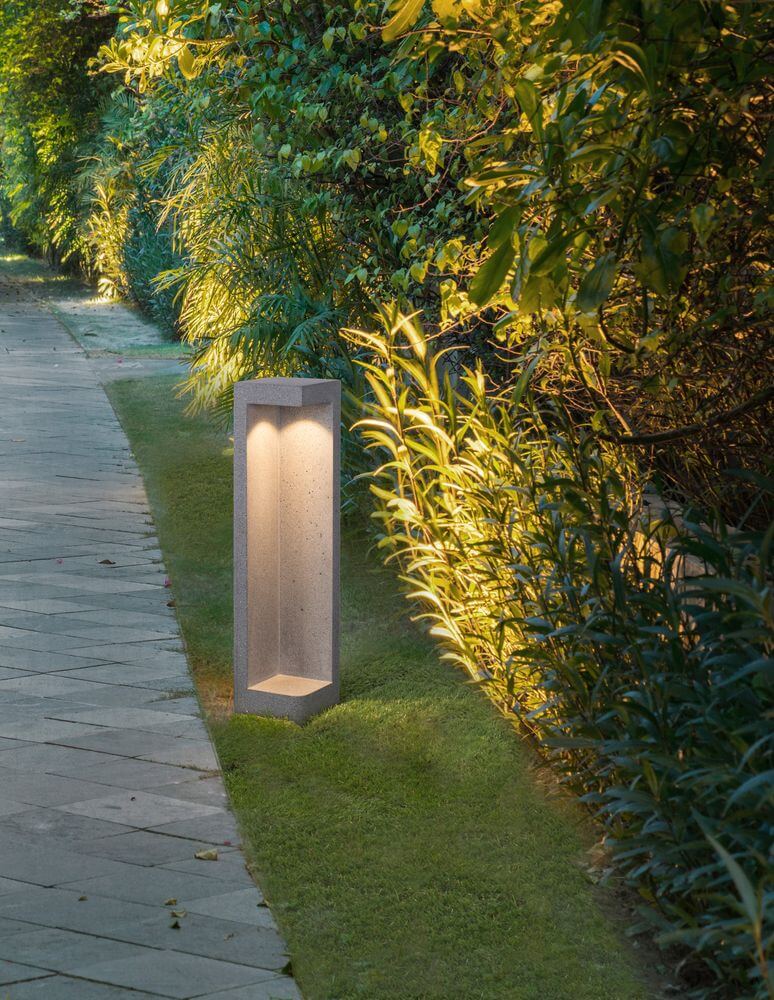 Grante LED Außenwegeleuchte 3000K Grau IP65 neben einer gepflegten Gartenwegbeleuchtung.