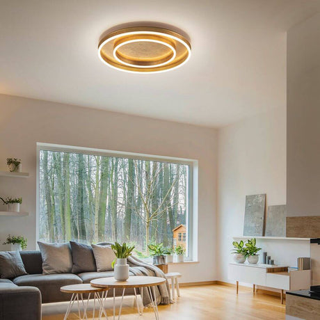 LED Deckenlampe Sona Blattgold in stilvollem Wohnzimmer mit modernen Möbeln und großem Fenster.