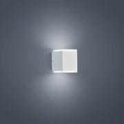 LED Wandaussenleuchte Kibo IP54 Weiß an einer Wand montiert, mit modernem Design und softem Licht.